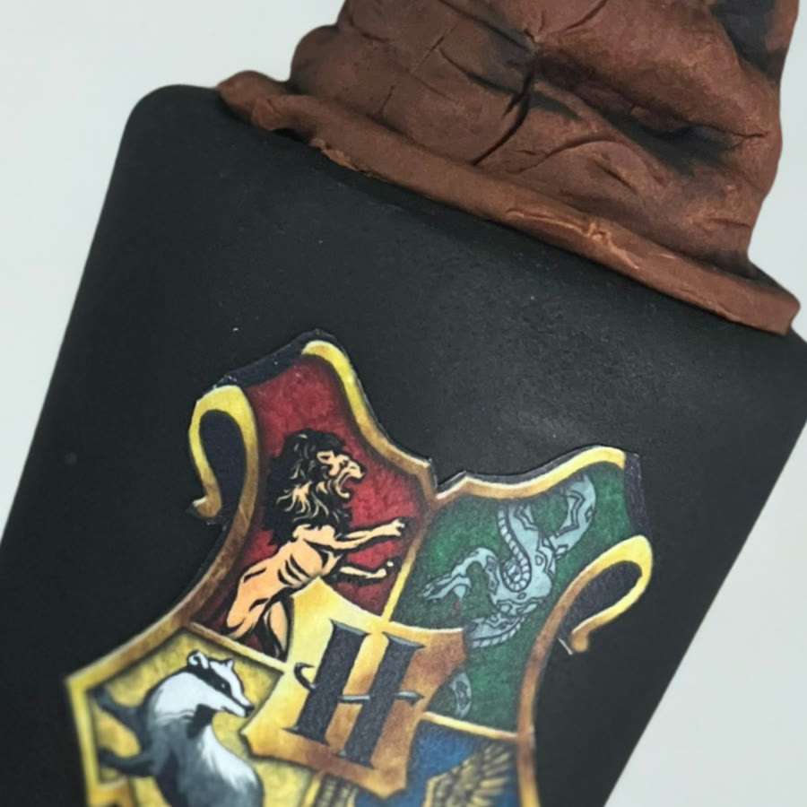 Close crop of a hand painted crest on black fondant.