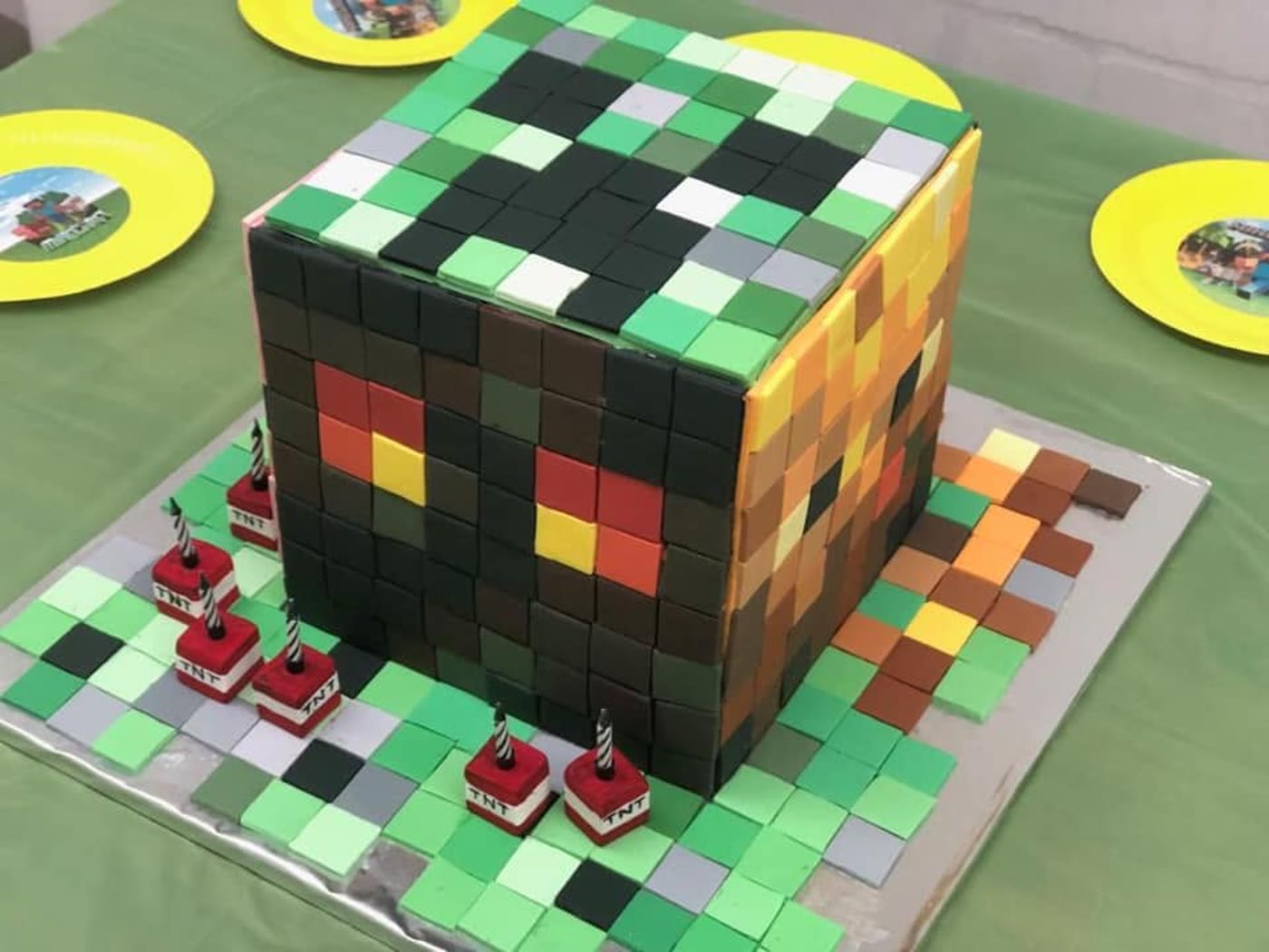 A cube cake tiled all over in small squares of fondant.