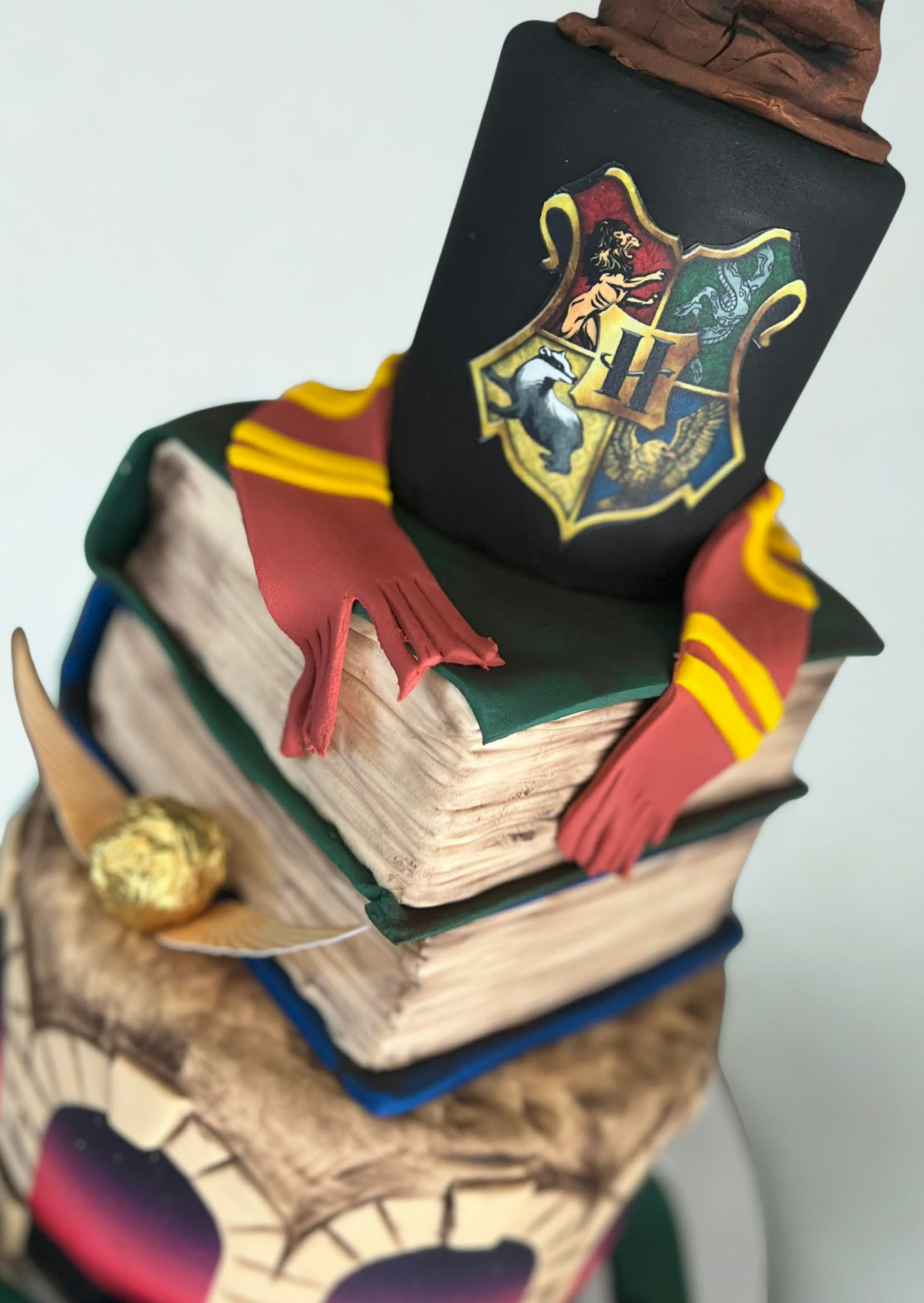 Stacked book cake with a sculpted pointed hat on top.