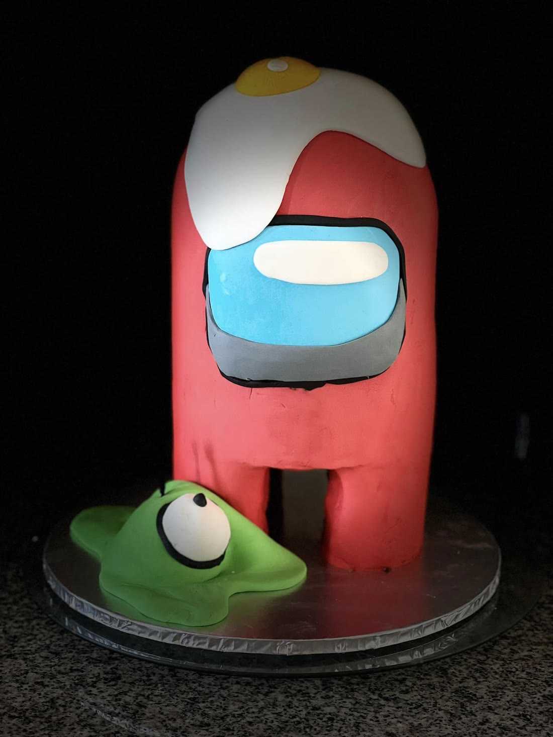 A tall carved character cake with a smooth red finish.