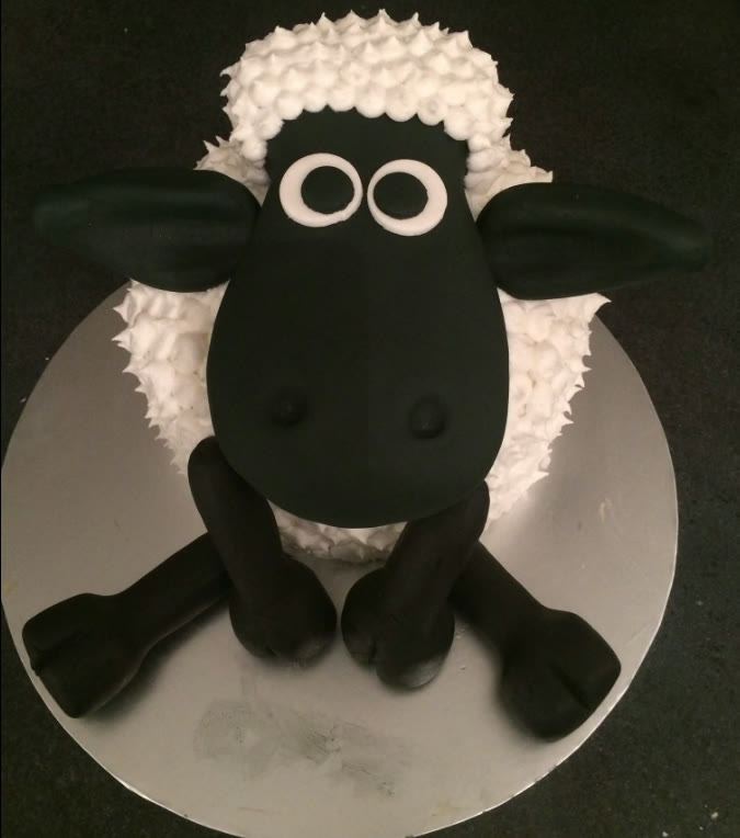 A cake sculpted as a sheep with a piped woolly coat.
